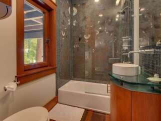 Experience luxury in this modern bathroom featuring a sleek glass-enclosed shower with unique fossil-inspired tilework.