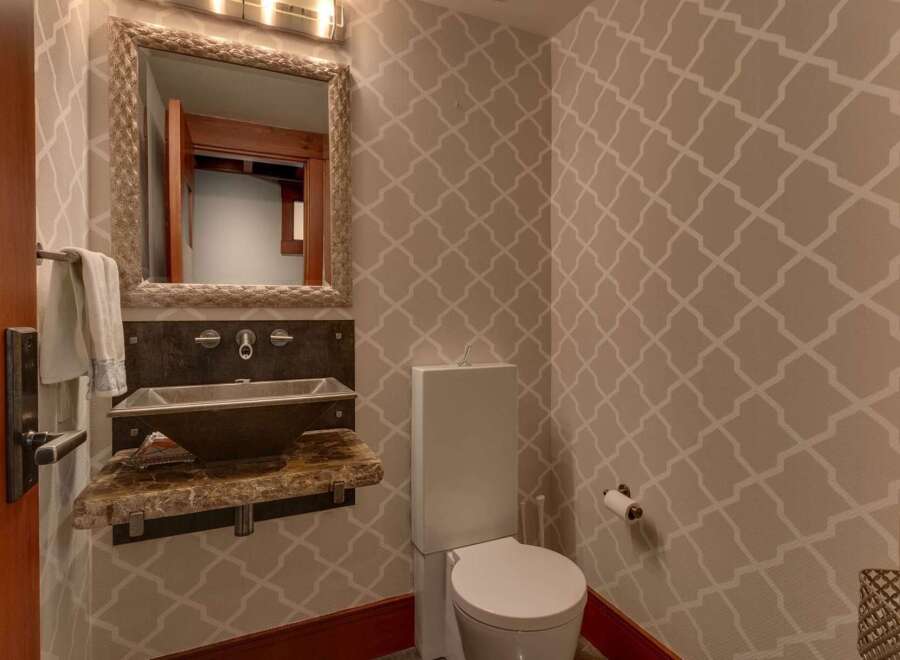 This powder room features a stylish geometric wallpaper that adds a modern touch to the space.
