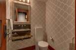 This powder room features a stylish geometric wallpaper that adds a modern touch to the space.