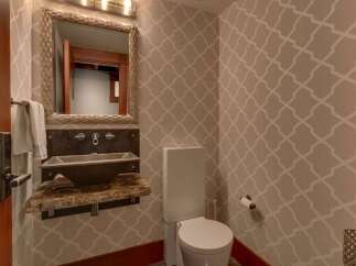 This powder room features a stylish geometric wallpaper that adds a modern touch to the space.