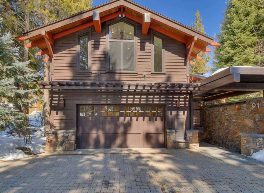 This stunning mountain home features a rustic yet modern exterior with rich wood siding and stone accents.