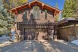 This stunning mountain home features a rustic yet modern exterior with rich wood siding and stone accents.