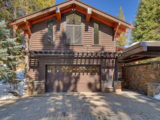 This stunning mountain home features a rustic yet modern exterior with rich wood siding and stone accents.