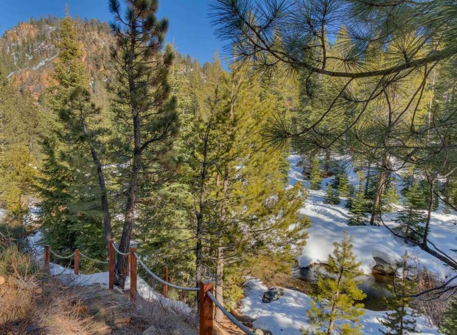Experience the serene beauty of this mountain retreat, nestled amidst snow-dusted pines and a gentle stream.