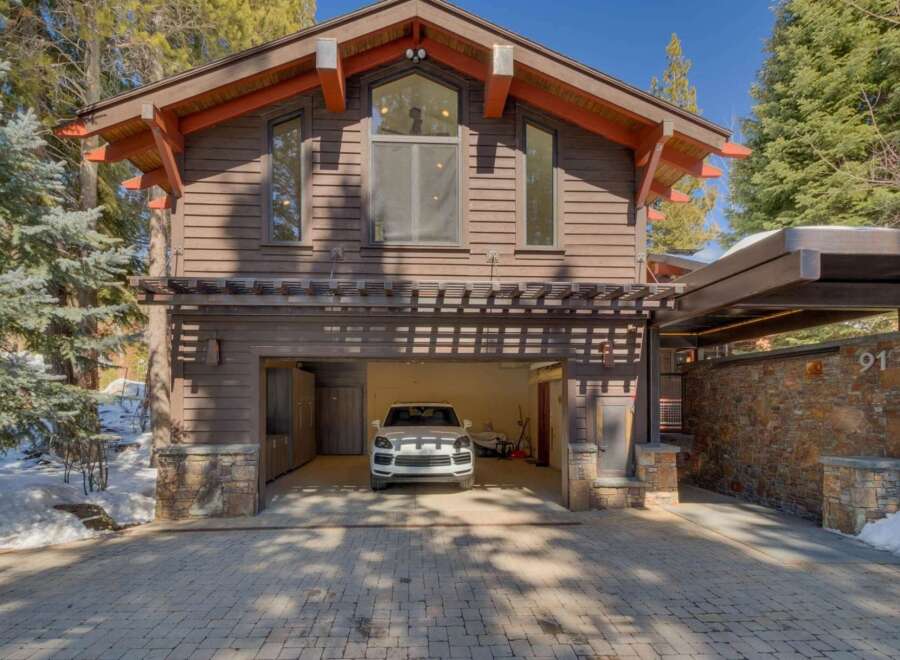 This stunning mountain home features a rustic yet modern exterior with rich wood siding and stone accents.