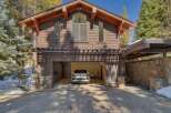 This stunning mountain home features a rustic yet modern exterior with rich wood siding and stone accents.