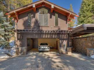This stunning mountain home features a rustic yet modern exterior with rich wood siding and stone accents.