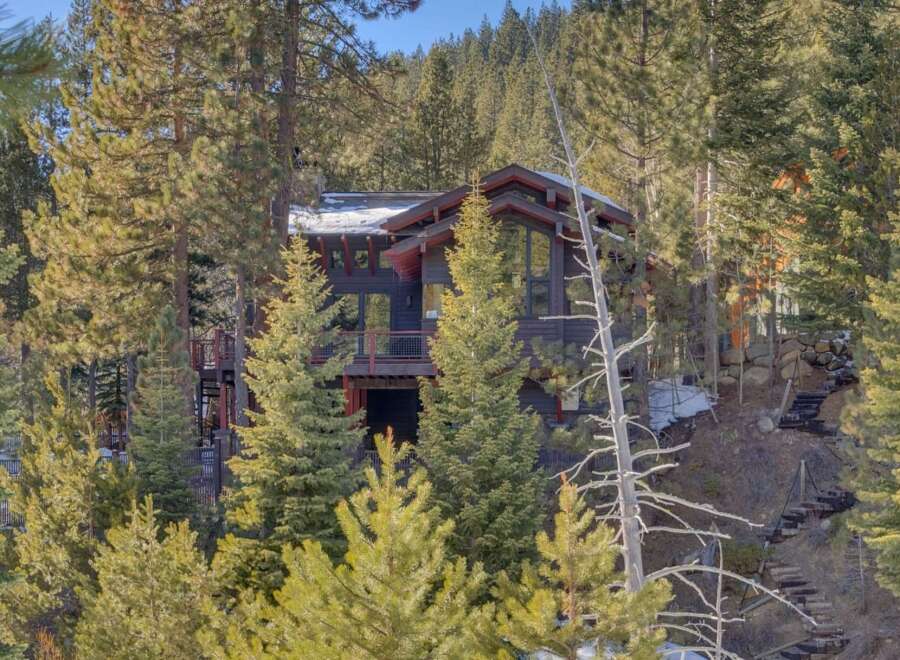 Nestled amidst a serene pine forest, this modern mountain home offers a unique architectural design with expansive windows that capture the natural beauty of its surroundings.
