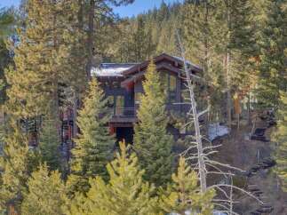 Nestled amidst a serene pine forest, this modern mountain home offers a unique architectural design with expansive windows that capture the natural beauty of its surroundings.