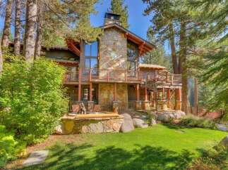 Experience luxury mountain living in this stunning home, featuring a grand stone fireplace and expansive decks perfect for entertaining.