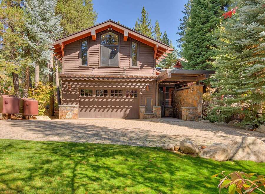 This stunning mountain home features a warm and inviting exterior with rich brown siding and natural stone accents.