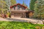 This stunning mountain home features a warm and inviting exterior with rich brown siding and natural stone accents.