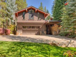 This stunning mountain home features a warm and inviting exterior with rich brown siding and natural stone accents.