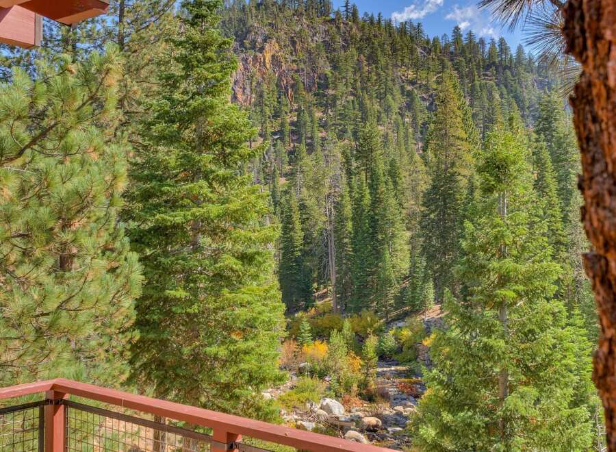 Experience breathtaking mountain views from this stunning property, nestled amidst a lush forest with a serene creek flowing below.