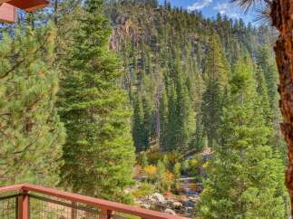Experience breathtaking mountain views from this stunning property, nestled amidst a lush forest with a serene creek flowing below.