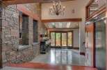 This grand entryway boasts a stunning stone accent wall and exposed wooden beams, creating a rustic yet luxurious feel.