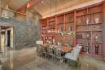 Experience rustic elegance in this stunning dining room, featuring a grand wooden dining table surrounded by plush chairs, perfect for hosting memorable gatherings.
