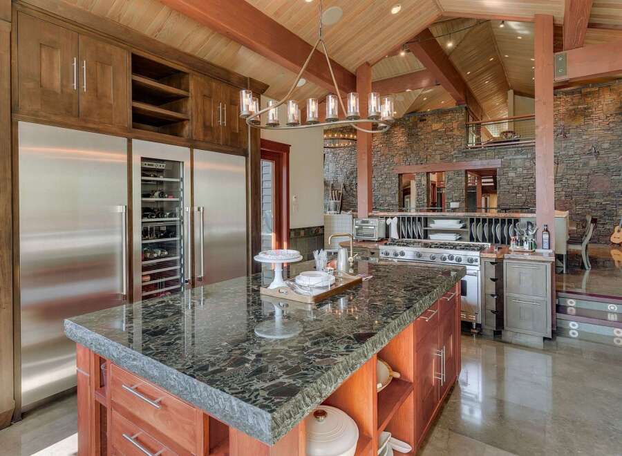 Experience luxury in this expansive gourmet kitchen, featuring a massive granite-topped island perfect for entertaining.