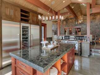Experience luxury in this expansive gourmet kitchen, featuring a massive granite-topped island perfect for entertaining.
