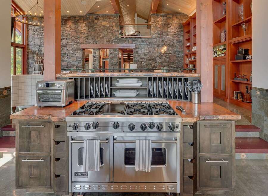 Experience culinary excellence in this stunning chef's kitchen, featuring a professional-grade Viking range and a spacious granite countertop perfect for meal preparation.