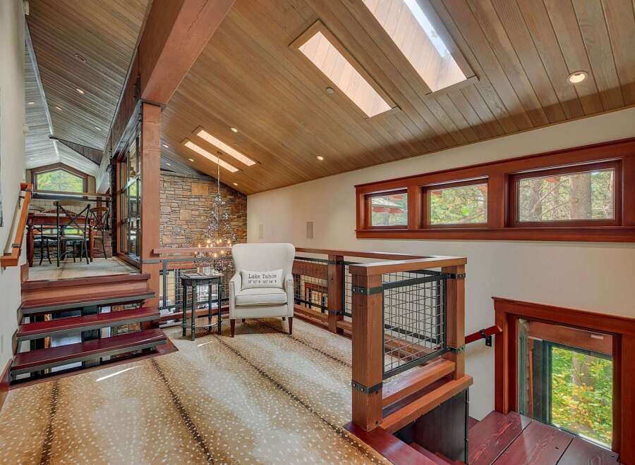 Experience luxury mountain living in this stunning home featuring a unique open-concept design with exposed wooden beams and a striking stone accent wall.