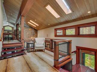 Experience luxury mountain living in this stunning home featuring a unique open-concept design with exposed wooden beams and a striking stone accent wall.
