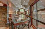 Experience rustic luxury in this stunning mountain home, featuring exposed wooden beams and a grand stone fireplace.
