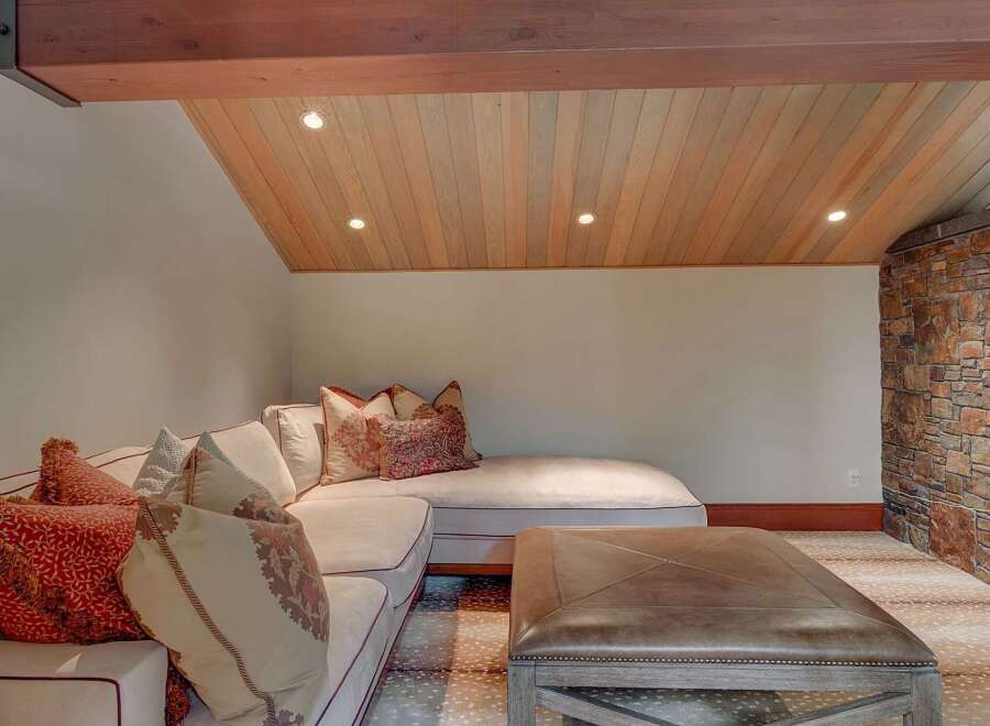 This cozy living space features a plush sectional sofa adorned with decorative pillows, perfect for relaxation.