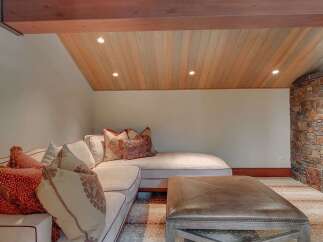 This cozy living space features a plush sectional sofa adorned with decorative pillows, perfect for relaxation.