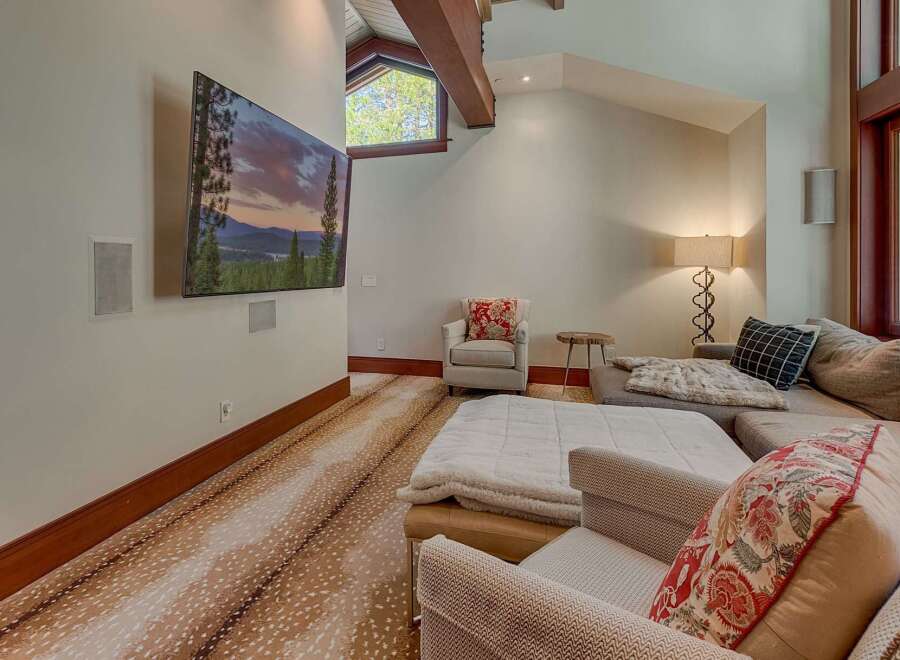 Experience ultimate relaxation in this spacious living area, featuring a large sectional sofa perfect for gatherings and a mounted flat-screen TV for entertainment.