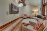 Experience ultimate relaxation in this spacious living area, featuring a large sectional sofa perfect for gatherings and a mounted flat-screen TV for entertainment.