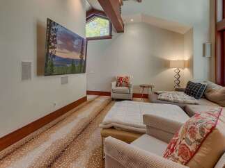 Experience ultimate relaxation in this spacious living area, featuring a large sectional sofa perfect for gatherings and a mounted flat-screen TV for entertainment.
