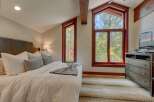 Experience rustic charm in this inviting bedroom, featuring a plush king-sized bed adorned with crisp white linens and decorative pillows.