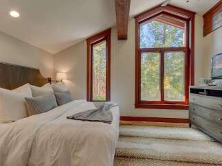 Experience rustic charm in this inviting bedroom, featuring a plush king-sized bed adorned with crisp white linens and decorative pillows.