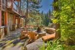 Experience the ultimate outdoor living with this stunning patio featuring a stone fire pit and comfortable Adirondack chairs, perfect for gathering with loved ones.
