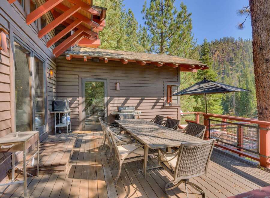 Enjoy outdoor living on this spacious wooden deck, perfect for entertaining or relaxing amidst a serene natural setting.