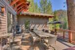 Enjoy outdoor living on this spacious wooden deck, perfect for entertaining or relaxing amidst a serene natural setting.