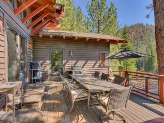 Enjoy outdoor living on this spacious wooden deck, perfect for entertaining or relaxing amidst a serene natural setting.
