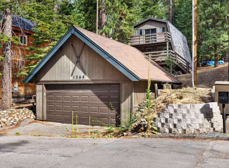 Discover this charming mountain property featuring a spacious garage with a distinctive ski motif and house number '1369'.