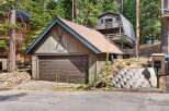 Discover this charming mountain property featuring a spacious garage with a distinctive ski motif and house number '1369'.