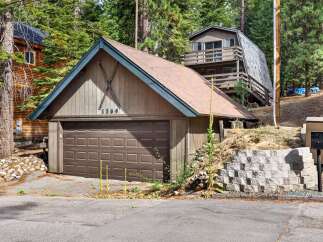 Discover this charming mountain property featuring a spacious garage with a distinctive ski motif and house number '1369'.