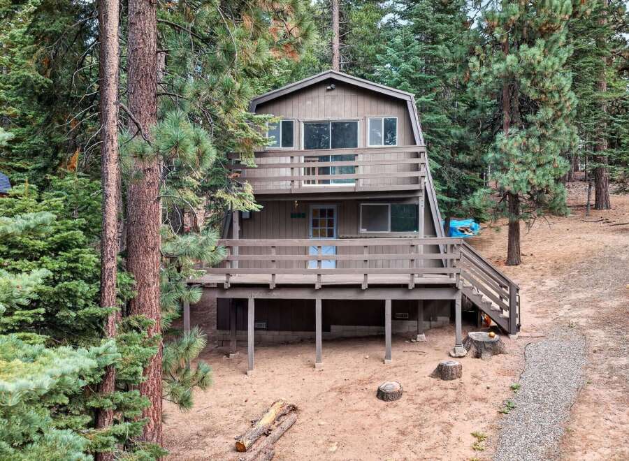 Nestled among tall pine trees, this charming A-frame cabin offers a serene mountain retreat.