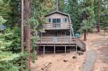 Nestled among tall pine trees, this charming A-frame cabin offers a serene mountain retreat.