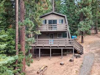 Nestled among tall pine trees, this charming A-frame cabin offers a serene mountain retreat.