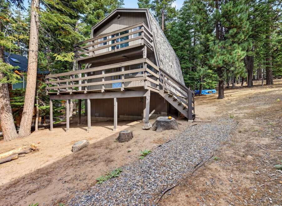 Discover this charming A-frame home nestled among tall pine trees, offering a unique architectural style and a serene natural setting.