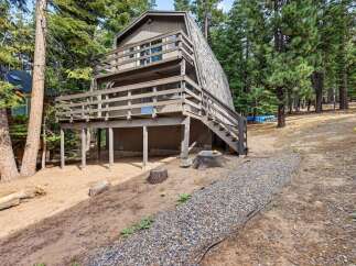 Discover this charming A-frame home nestled among tall pine trees, offering a unique architectural style and a serene natural setting.