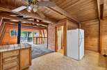 Experience rustic charm in this unique cabin-style kitchen, featuring warm wood paneling throughout and a cozy A-frame ceiling.