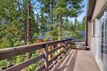 Enjoy the serene mountain views from this charming cabin deck, nestled amongst towering pine trees.
