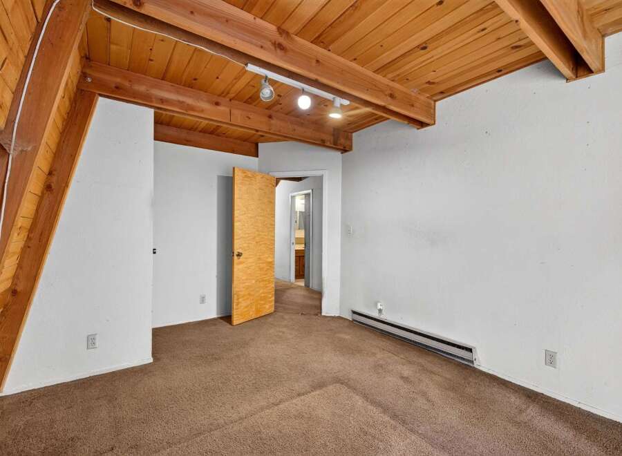 This charming room features a vaulted wood-paneled ceiling with exposed beams, creating a warm and rustic ambiance.