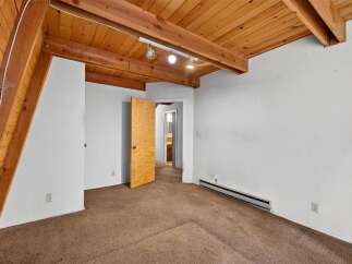 This charming room features a vaulted wood-paneled ceiling with exposed beams, creating a warm and rustic ambiance.